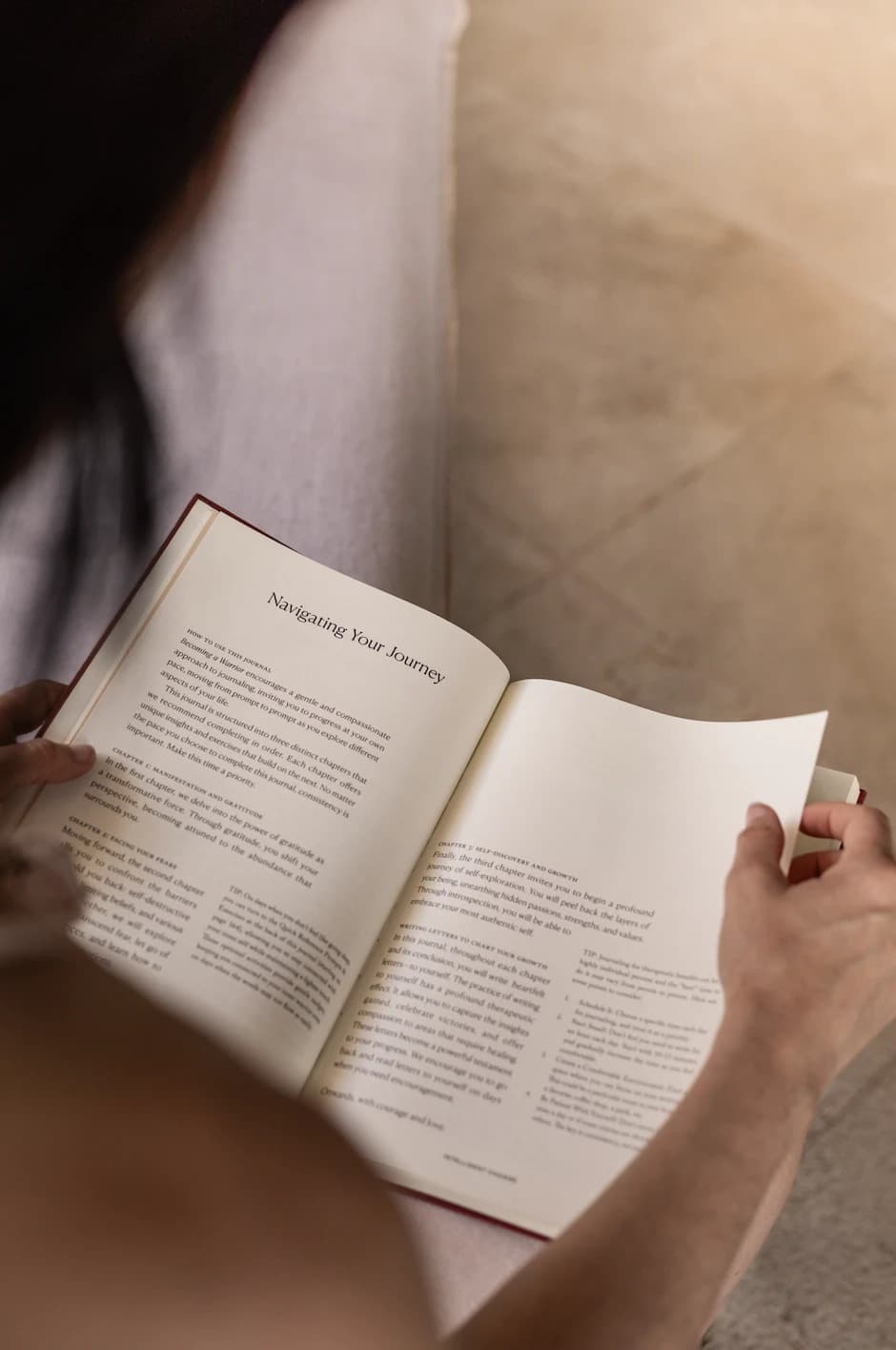 Hands holding an open journal during a reflective reading moment